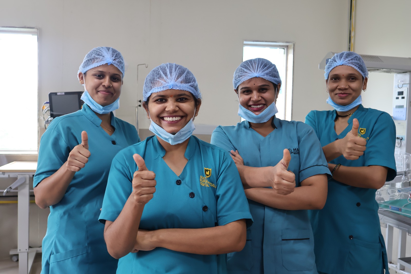Four members of Mamta's clinical nursing team in blue hospital scrubs
